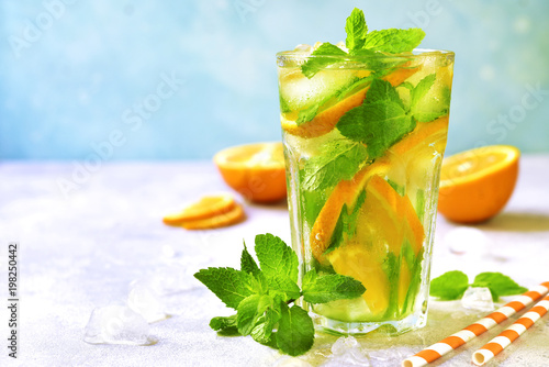 Homemade orange lemonade with mint in a tall glass.