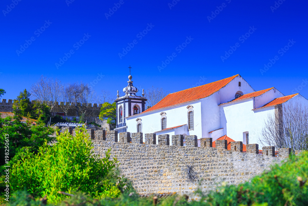 View of the beautiful medieval historic center village of Obidos and Castle of Obidos. Wonderful romantic afternoon landscape at sunny weather. District of Leiria, in the centre of Portugal.