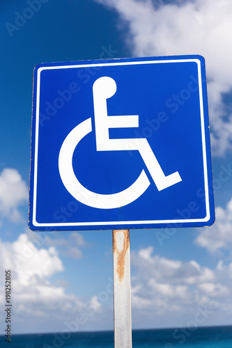 Blue handicapped sign with wheelchair, outdoors