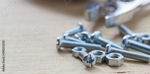 Bolts and nuts on the wooden table