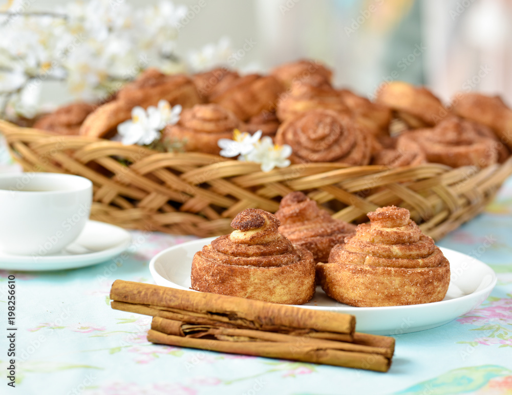 Fototapeta premium Cinnamon buns with tea and spring flowes