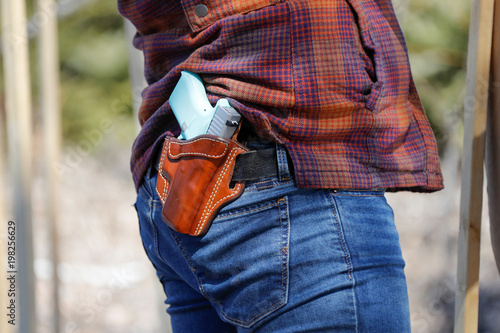 A person wearing a holster with a handgun. photo
