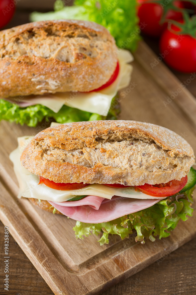 Wholegrain Ciabatta Sandwich with Lettuce, Tomatoes, Ham and Cheese Wholegrain Ciabatta Sandwich with Lettuce, Tomatoes, Ham and Cheese