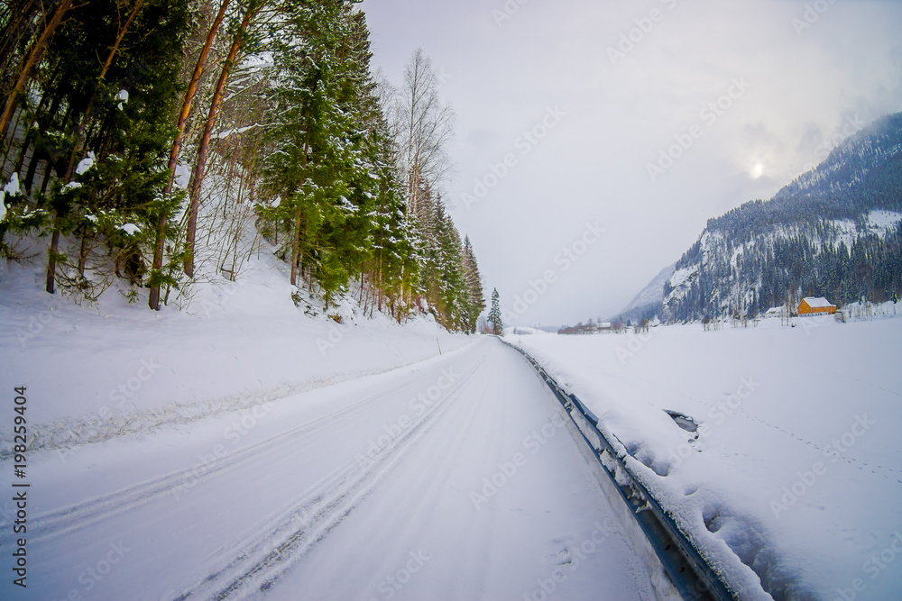 Outdoor view of winter road snow and ice in the forest of Norway Outdoor view of winter road snow and ice in the forest of Norway