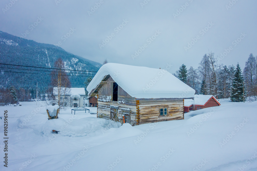 View of traditional Norwegian mountain wooden houses covered with snow in stunning nature background in Norway