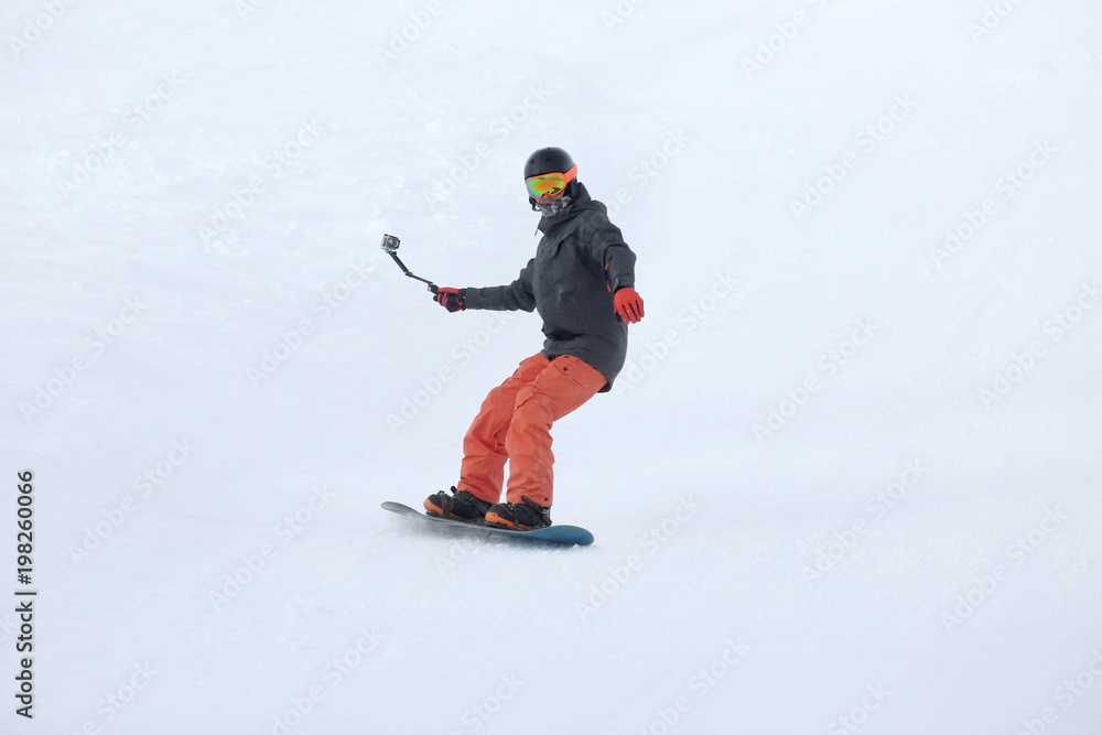 Snowboarder on ski piste at snowy resort. Winter vacation Snowboarder on ski piste at snowy resort. Winter vacation