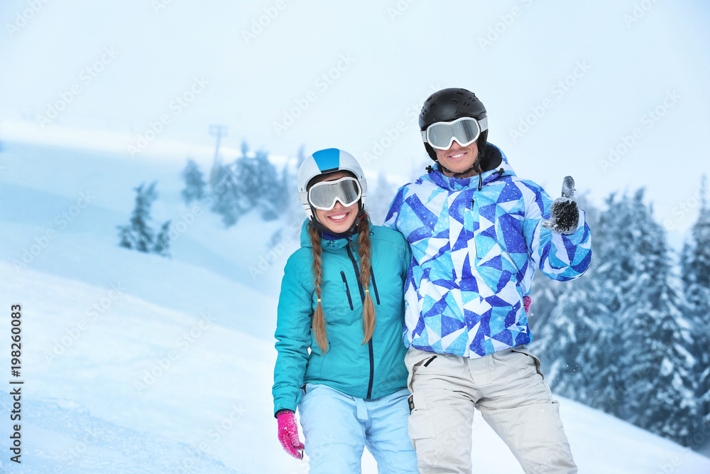 Couple on ski piste at snowy resort. Winter vacation Couple on ski piste at snowy resort. Winter vacation