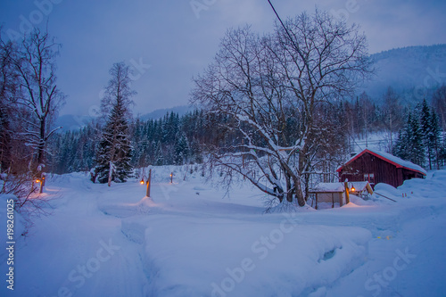 Amazing night view of traditional wooden houses with snow in the roof in stunning nature background, with some lights and posts at outdoors in Valdres region in Norway © Fotos 593