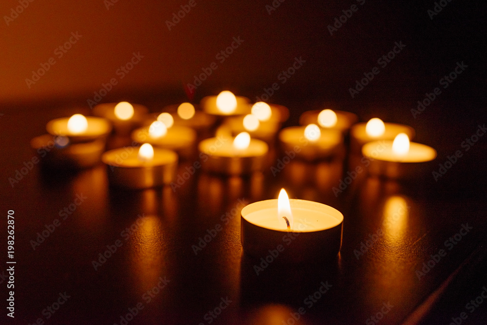 Kemerovo, Russia, fire in the mall, burning candles. Shallow depth of field. Many candles burning at night. Candles background. Many candle flames glowing on dark background. Close-up. Free space.