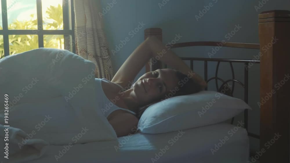 Portrait of just awake young woman lying in bed at home at morning. Portrait of just awake young woman lying in bed at home at morning.