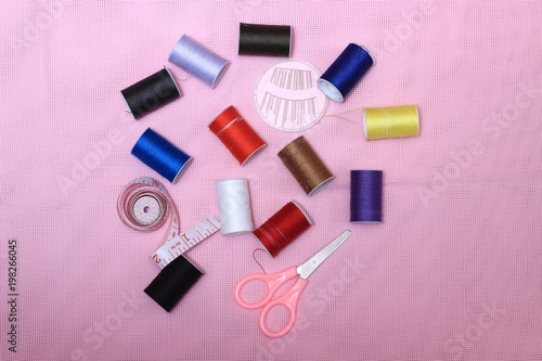 Flat lay or top view, Needle Scissor, Thread, Tailor Meter, Scissor at Pink Background