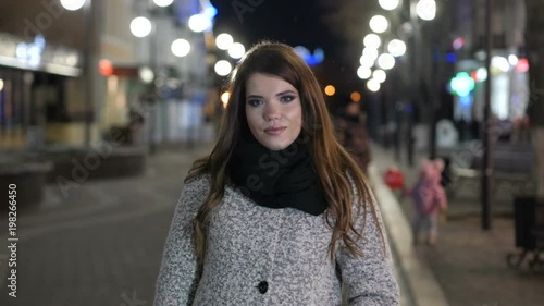 Beautiful attractive girl in the middle of a night city. photo