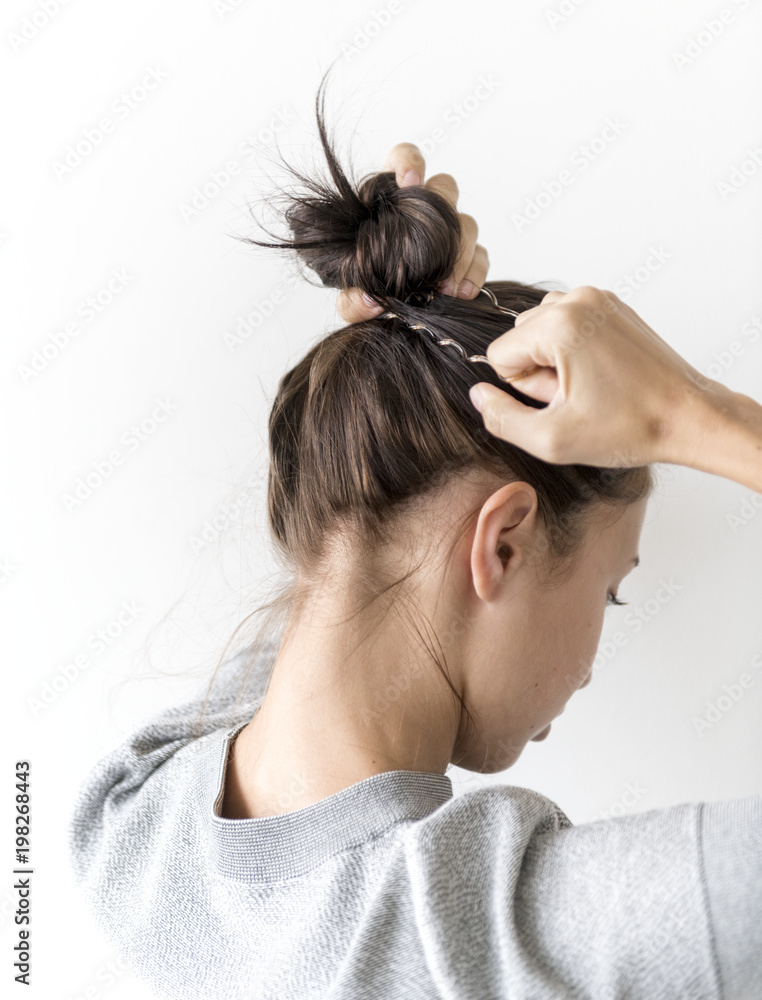 Naklejka premium Woman making hair bun
