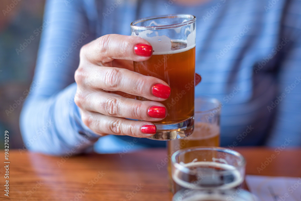 macro closeup of woman holding a glass from beer flight macro closeup of woman holding a glass from beer flight