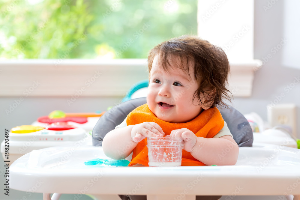 Happy little baby boy with a big smile eating food Happy little baby boy with a big smile eating food