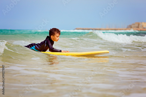 guy conquers the waves on the surfboard photo