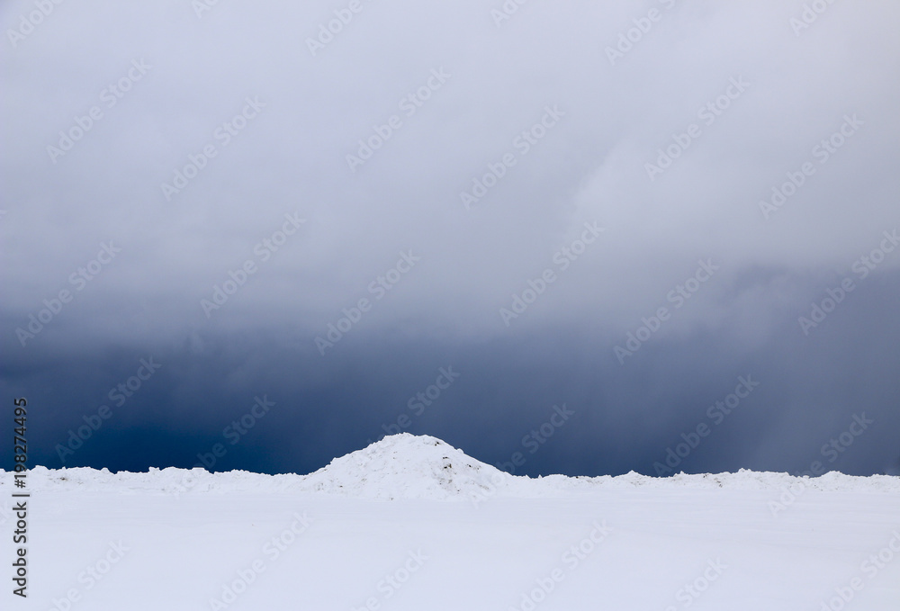 snow field. The plain is covered with white snow under a blue sky with thick white clouds. before a snowfall, a storm, a snowstorm. premonition of a blizzard. in anticipation of a blizzard. snow field. The plain is covered with white snow under a blue sky with thick white clouds. before a snowfall, a storm, a snowstorm. premonition of a blizzard. in anticipation of a blizzard.