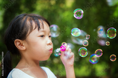 Asian girl play a bubble in nature, this picture can use for kid, nature, play, child. and summer concept