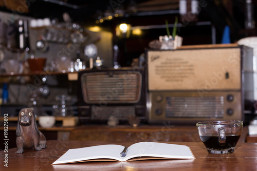 Black coffee cup and wooden desk diary