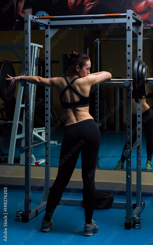 Fototapeta premium Woman with the barbell in the gym 