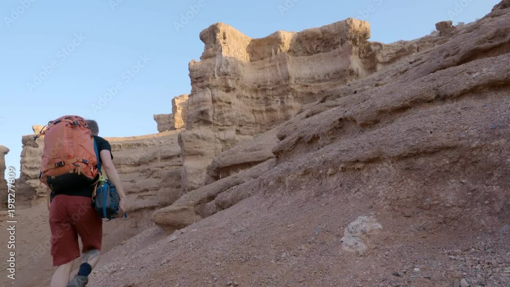 Adventure climber in desert canyon in Kazakhstan Adventure climber in desert canyon in Kazakhstan