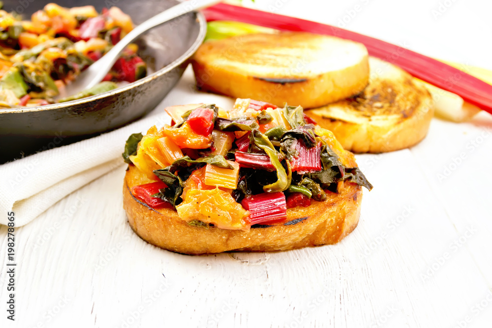 Bruschetta with stewed chard and orange on board