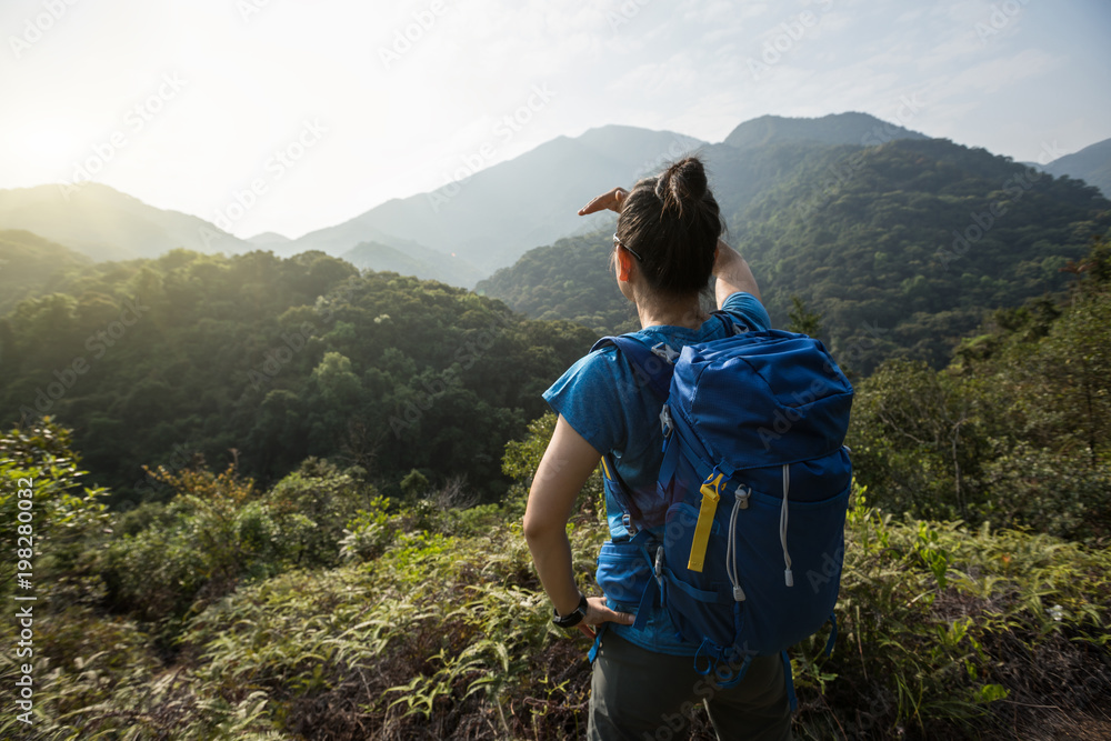 female backpacker enjoying the view on morning mountain valley