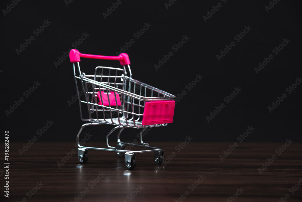 Shopping cart or supermarket trolley in dark room, business finance shopping concept.