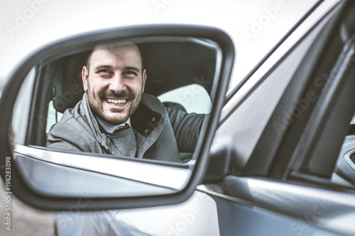 Smiling man in car. © Mladen