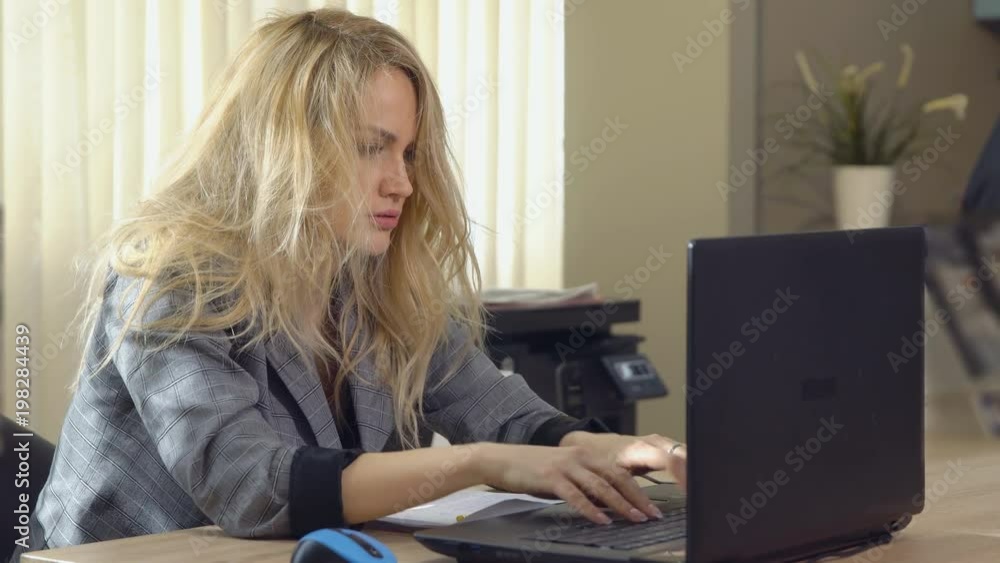 tired business woman in suit works at the computer in office tired business woman in suit works at the computer in office