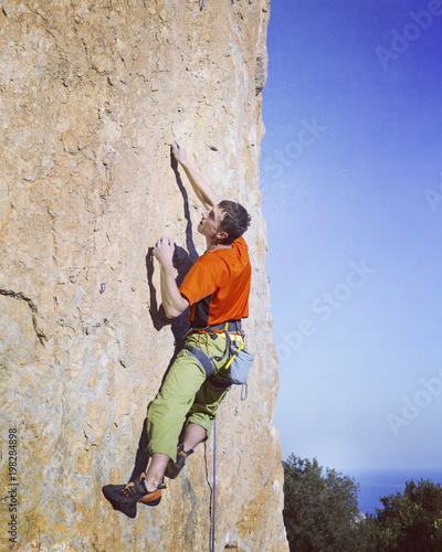 Fototapeta Naklejka Na Ścianę i Meble -  Rock-climbing in Turkey. The climber climbs on the route. Photo from the top.