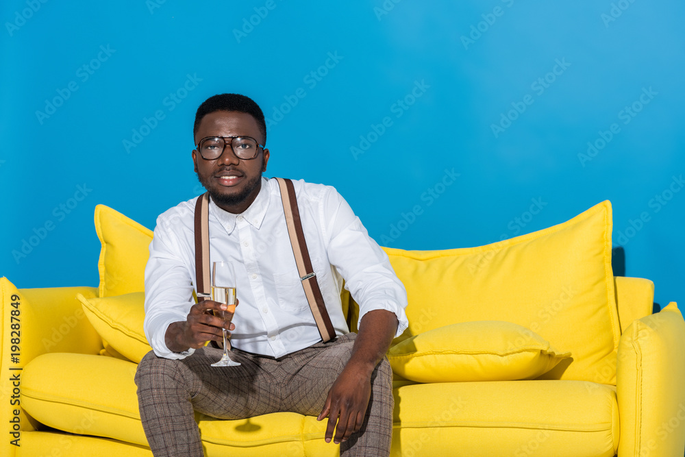 stylish young african american man holding glass of wine and smiling at camera stylish young african american man holding glass of wine and smiling at camera