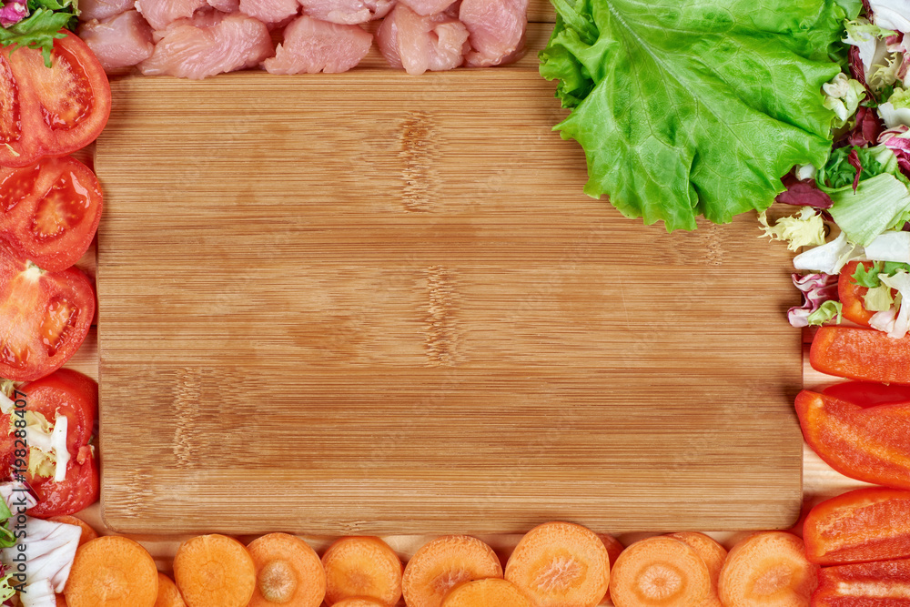 Frame of fresh vegetables and dietary meat on wooden background. Healthy natural food on table with copy space. Cooking ingredients top view, mockup for recipe or menu Frame of fresh vegetables and dietary meat on wooden background. Healthy natural food on table with copy space. Cooking ingredients top view, mockup for recipe or menu