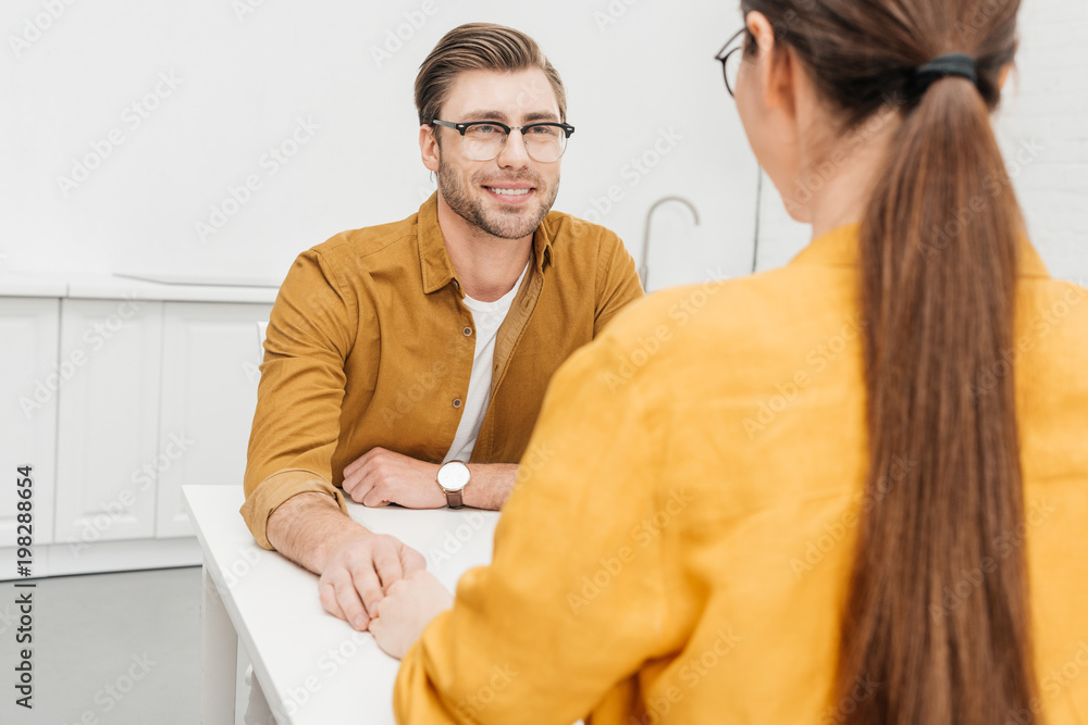 Obraz premium happy loving couple sitting on kitchen together and chatting