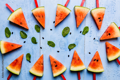 summer concept watermelon slice popsicles on a blue rustic wood background