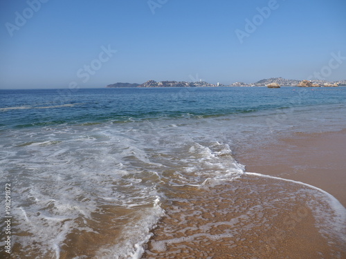 Panorama of beauty sandy beach at bay of ACAPULCO city in Mexico and waves of Pacific Ocean