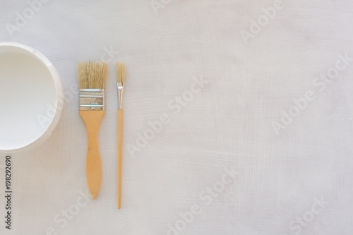 Paint brush and other painting supplies on white wooden planks, top view Brush on a wooden background, top view.