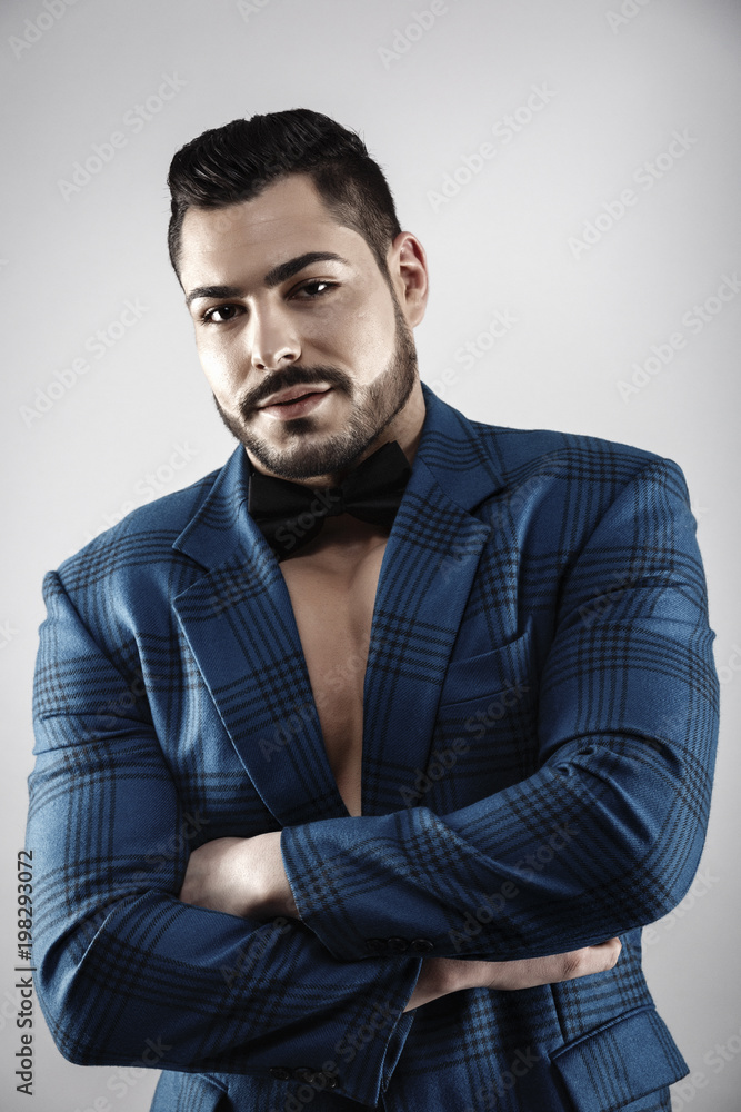 Fototapeta premium Handsome muscular young bodybuilder showing his muscles and abs while posing shirtless