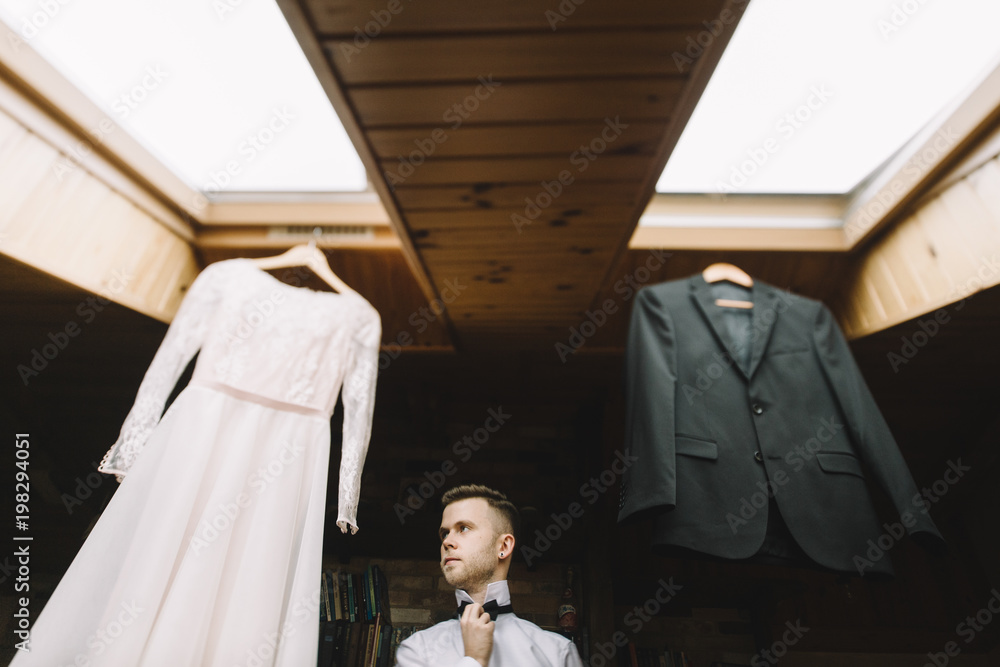 the groom adjusts his jacket, groom in a jacket, The morning of 