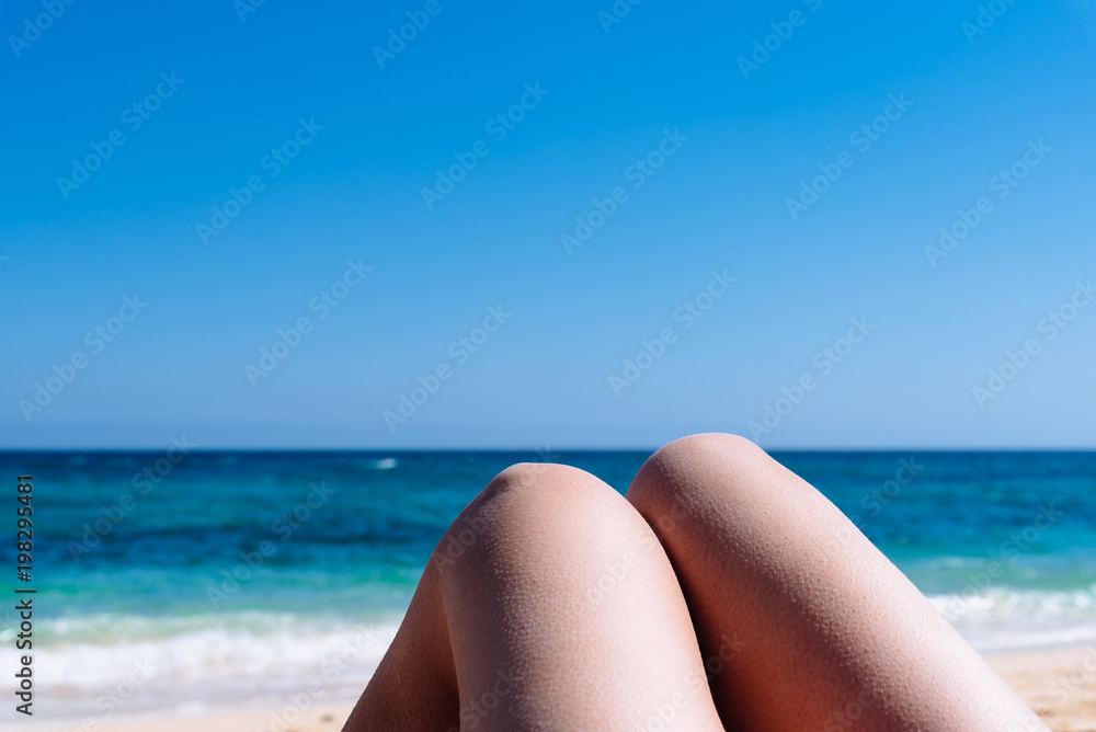 Mature woman legs sunbathing on the beach Mature woman legs sunbathing on the beach