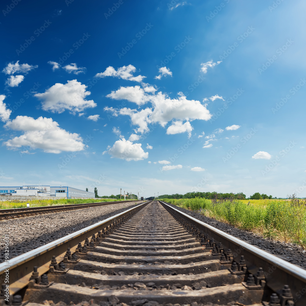 railroad closeup to horizon and blue sky with clouds