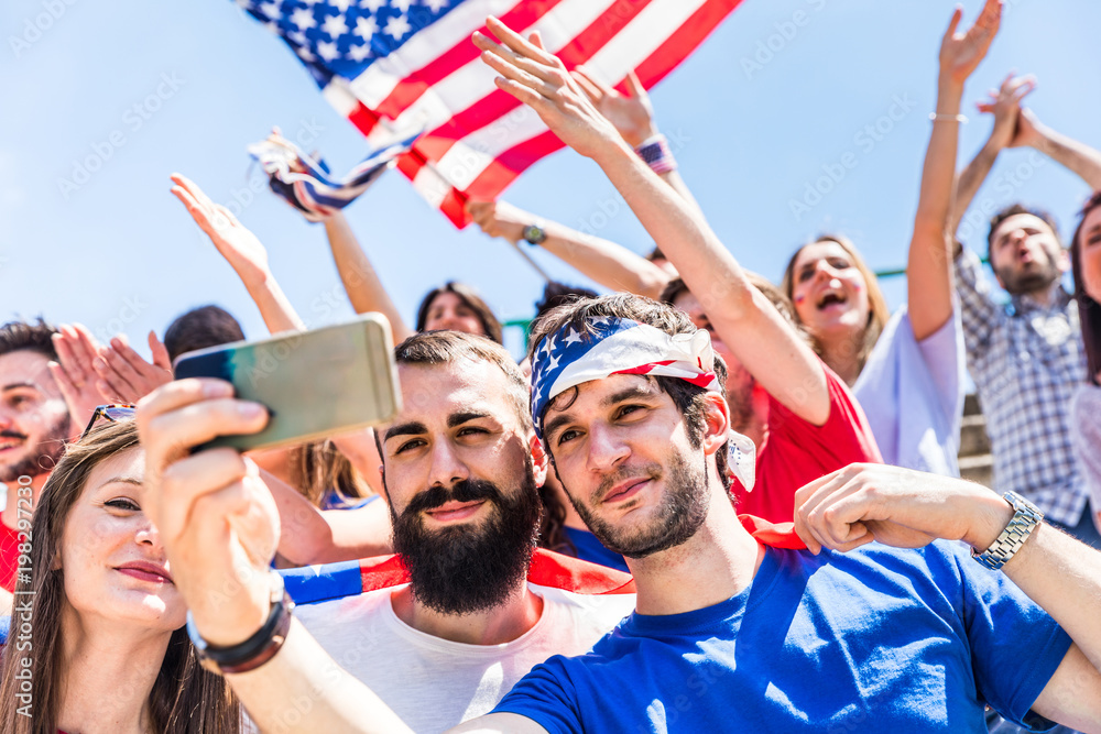 Obraz premium American fans taking a selfie at stadium during a match