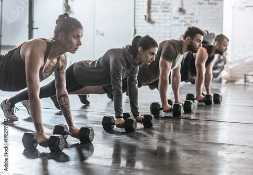 Obraz Sportowcy robią pompki na siłowni