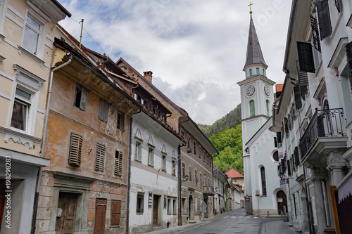 Street A small town in the mountains of Slovenia, Europe. Shabby old houses facades, and roofs. Center of the city and the Catholic Church