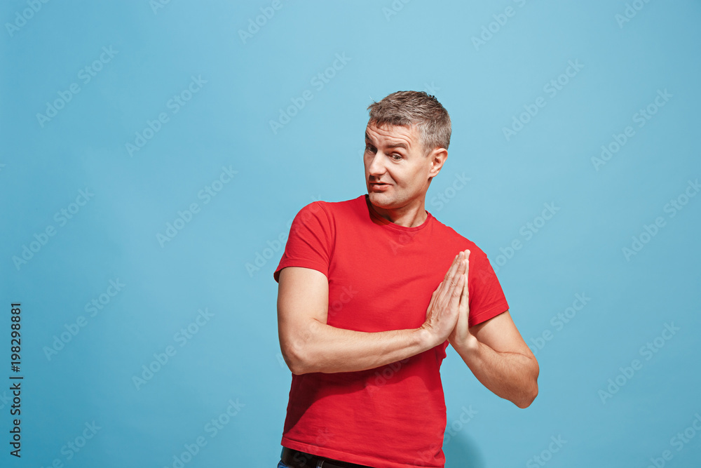 The happy business man standing and smiling against blue background. The happy business man standing and smiling against blue background.