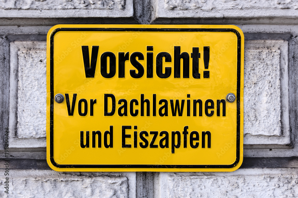 Germany: Yellow warning sign on an exterior wall: Watch out! Roof avalanche and icicles (Vorsicht! Dachlawinen und Eiszapfen) - concept danger winter ice frost snow hazard risk advice information Germany: Yellow warning sign on an exterior wall: Watch out! Roof avalanche and icicles (Vorsicht! Dachlawinen und Eiszapfen) - concept danger winter ice frost snow hazard risk advice information