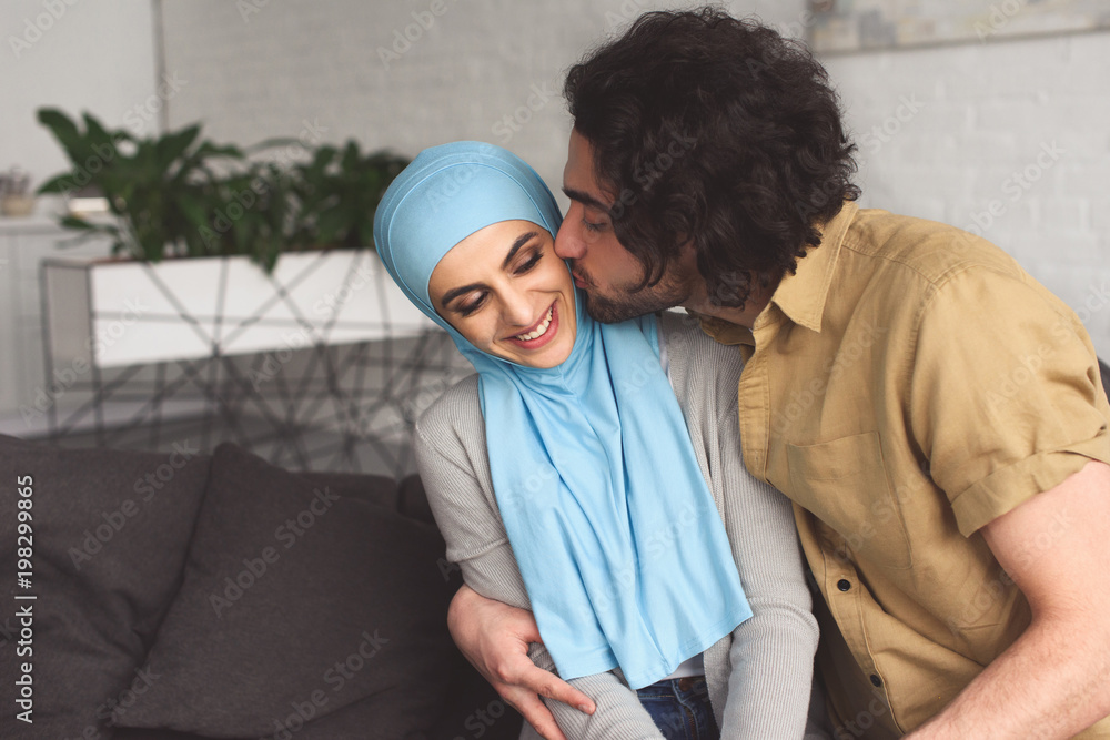 muslim boyfriend kissing girlfriend in hijab at home muslim boyfriend kissing girlfriend in hijab at home