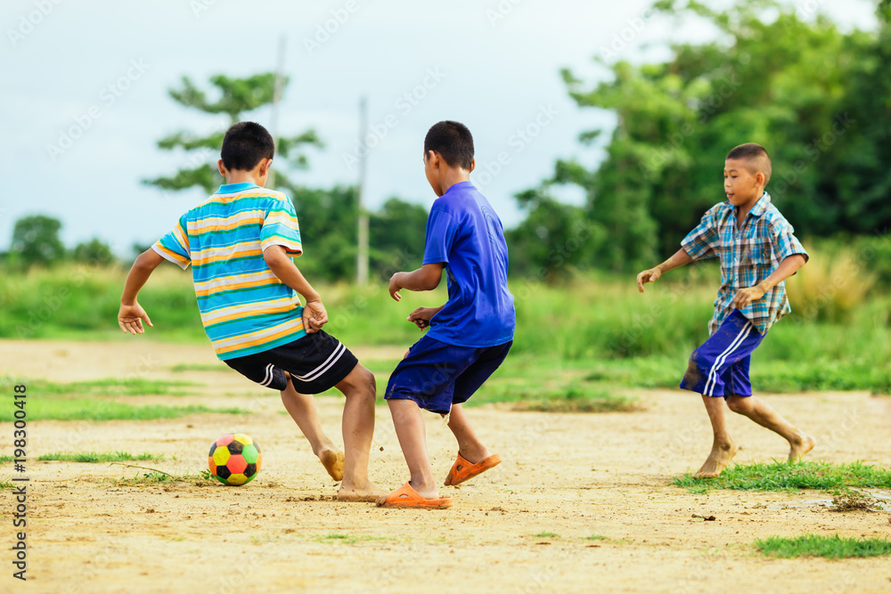 Obraz premium An action sport picture of a group of kid playing soccer football for exercise in community rural area 