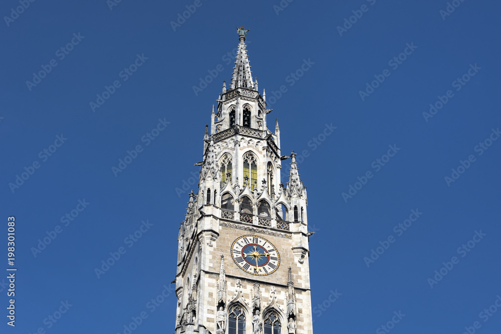 Germany, Bavaria, Munich, Marienplatz: Front view detail of famous clock tower of the New Town Hall (Neues Rathaus) in the city center of the Bavarian capital with blue sky in the background.