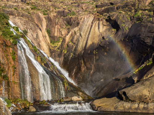 Waterfall on the river Jallas with rainbow, also called waterfall of Ezaro, Galicia, Spain. This waterfall pours the water directly to the sea photo